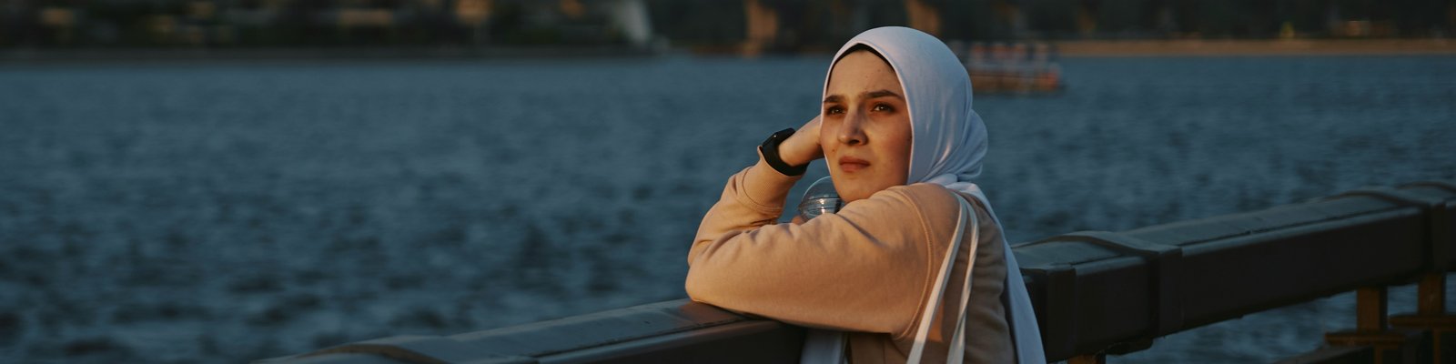 muslim woman facing camera beach skyline