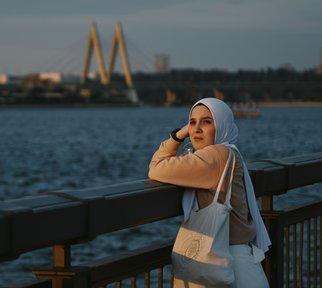 muslim woman facing camera beach skyline