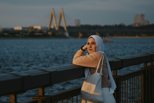muslim woman facing camera beach skyline