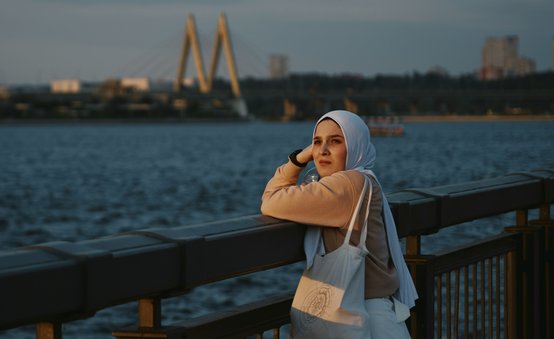 muslim woman facing camera beach skyline