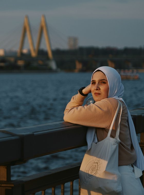muslim woman facing camera beach skyline