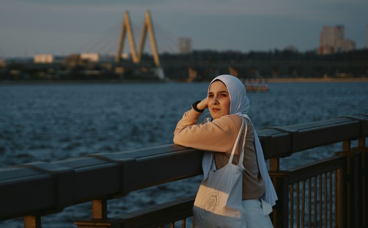 muslim woman facing camera beach skyline