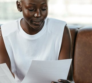 A Black woman reading a piece of paper