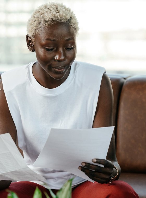 A Black woman reading a piece of paper